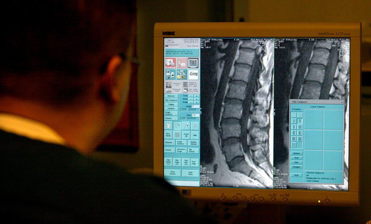 A technician views an MRI of a patient's spine. A new study says doctors are failing to follow established guidelines for the treatment of back pain. Among other problems, the study cites overuse of diagnostic imaging.