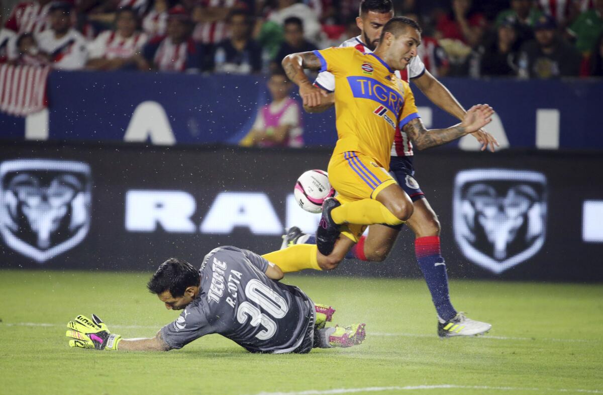 Tigre UANL's Victor Sosa, top, collides with Chivas de Guadalajara goalkeeper Rodolfo Cota, earning Sosa a yellow card in the first half of a Champion of Champions (Campeon de Campeones) soccer match in Carson, Calif., Sunday, July 16, 2017. (AP Photo/Reed Saxon)