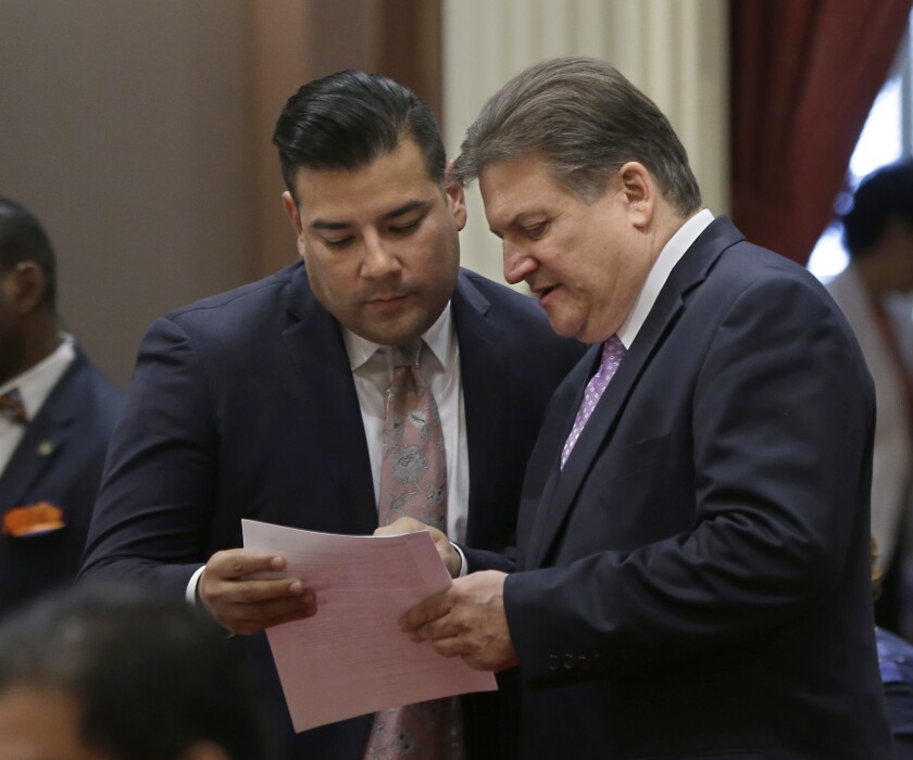 Sen. Ricardo Lara (D-Bell Gardens), left, discusses a bill with Sen. Robert Hertzberg (D-Van Nuys) at the Capitol in Sacramento on Sept. 10, 2015. Lara authored a measure implementing the state's expansion of healthcare for children who are in the country illegally.
