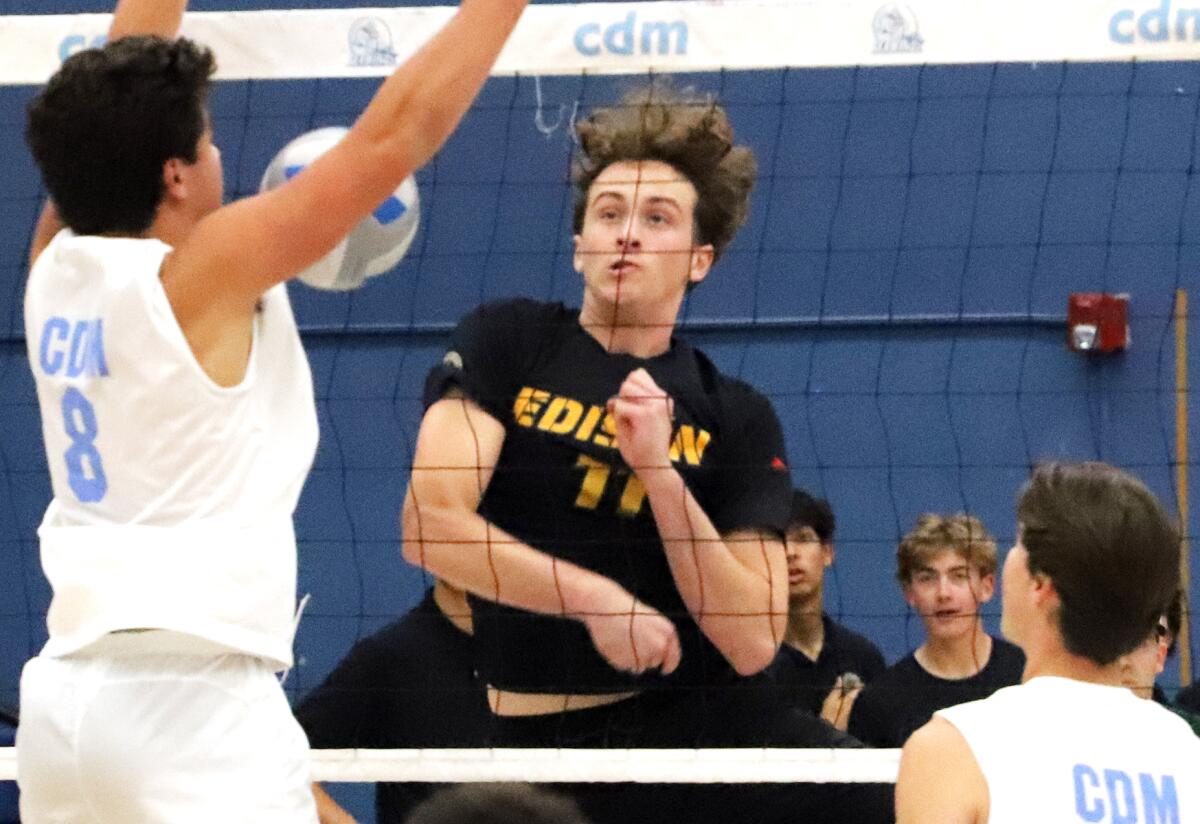 Edison's Connor McNally (11) spikes past Corona del Mar's Reid McMullen (8) on Wednesday.