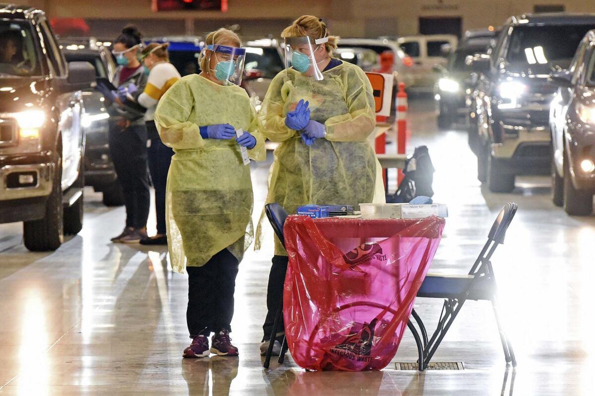 Nurses Crys Kuntz, left, and Sara Nelson confer inside the Bismarck Event Center.