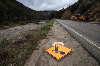 Lake Hughes, CA - March 30: A loader moves rocks and mud along Lake Hughes Road, where closures persist on Thursday, March 30, 2023 in Lake Hughes, CA. (Brian van der Brug / Los Angeles Times)