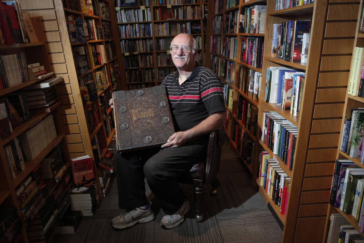 Owner Clarey Rudd holds an 1877 copy of "Faust" by Goethe at Malibu's Bank of Books in December 2012. The store will close in April.