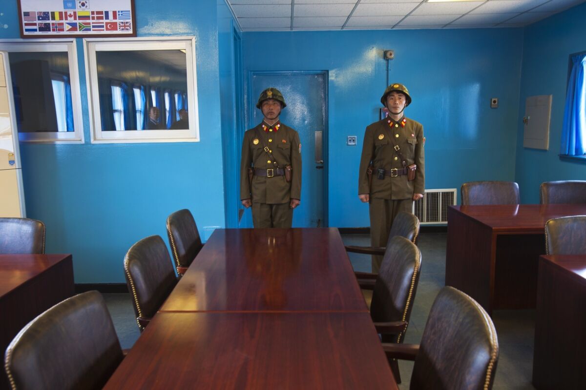 In this 2011 file photo, North Korean soldiers stand guard inside the building shared by North and South Korea at the truce village of Panmunjom.