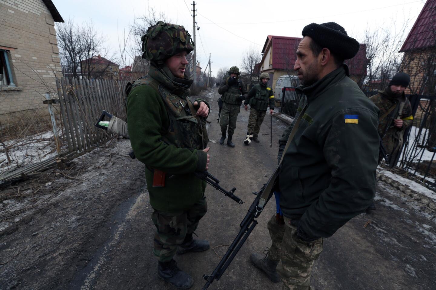 On the outskirts of Donetsk, Maxim Bugel, left, a Ukrainian platoon commander, talks to a survivor of the airport siege.