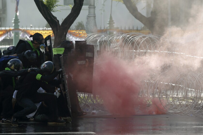 Riot police launch tear gas to protesters marching to Government House in Bangkok, Thailand Sunday, July 18, 2021. Hundreds of anti-government protesters rallied on Sunday despite the government’s recent measures to prohibit the gathering of more than 5 people in the capital to curb the COVID-19 pandemic. Protesters demanded the resignation of Prime Minister Prayuth Chan-ocha and his cabinet.(AP Photo/Anuthep Cheysakron)