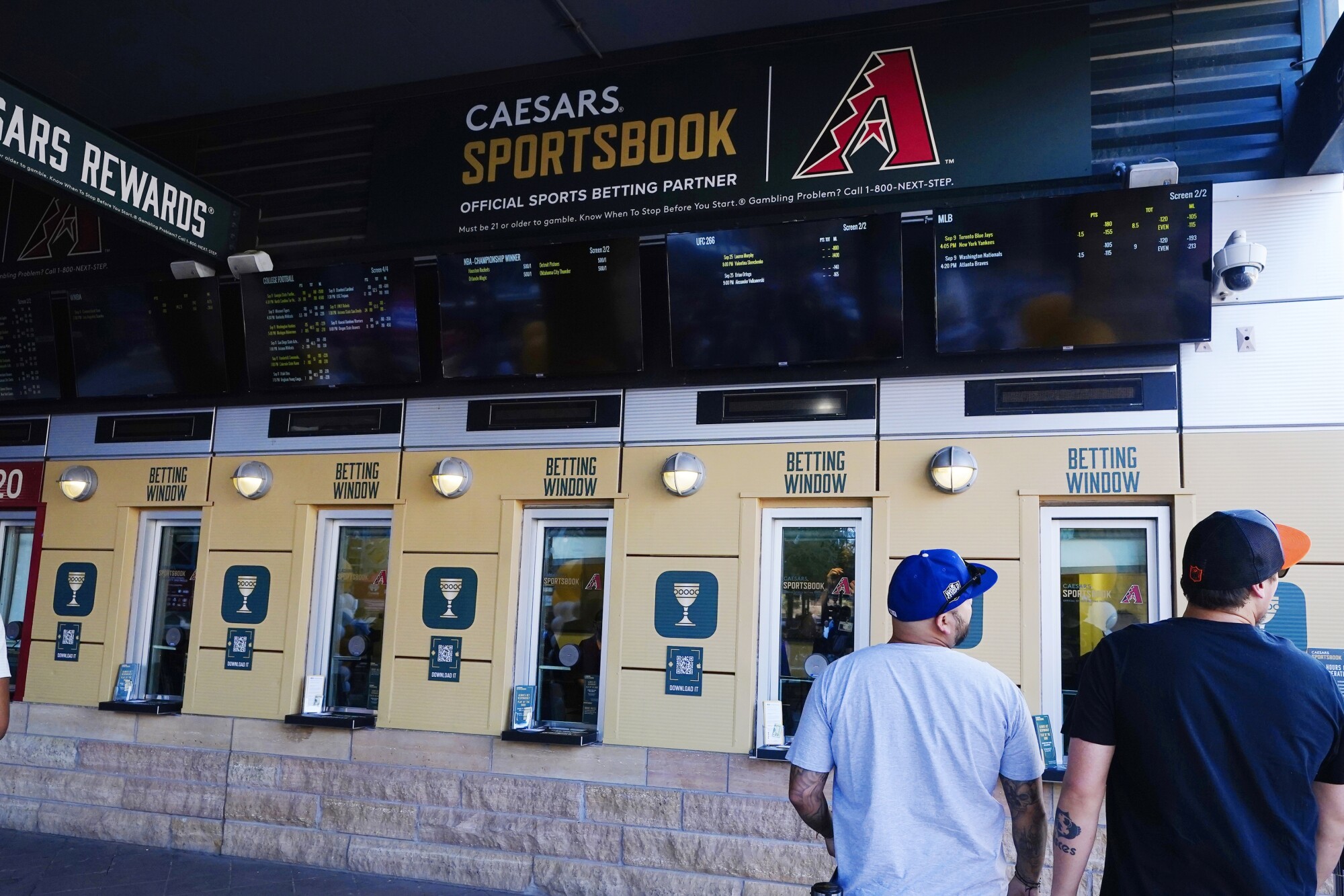 Bettors get in line at a temporary sports betting window at the Diamondbacks' Chase Field.
