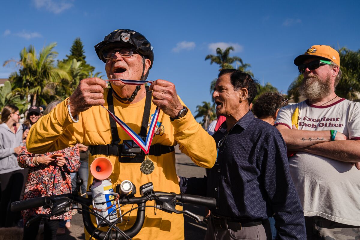 Al Merritt, 83 years old, holds a medal that is given to him after he rides his bicycle back home in Carlsbad 