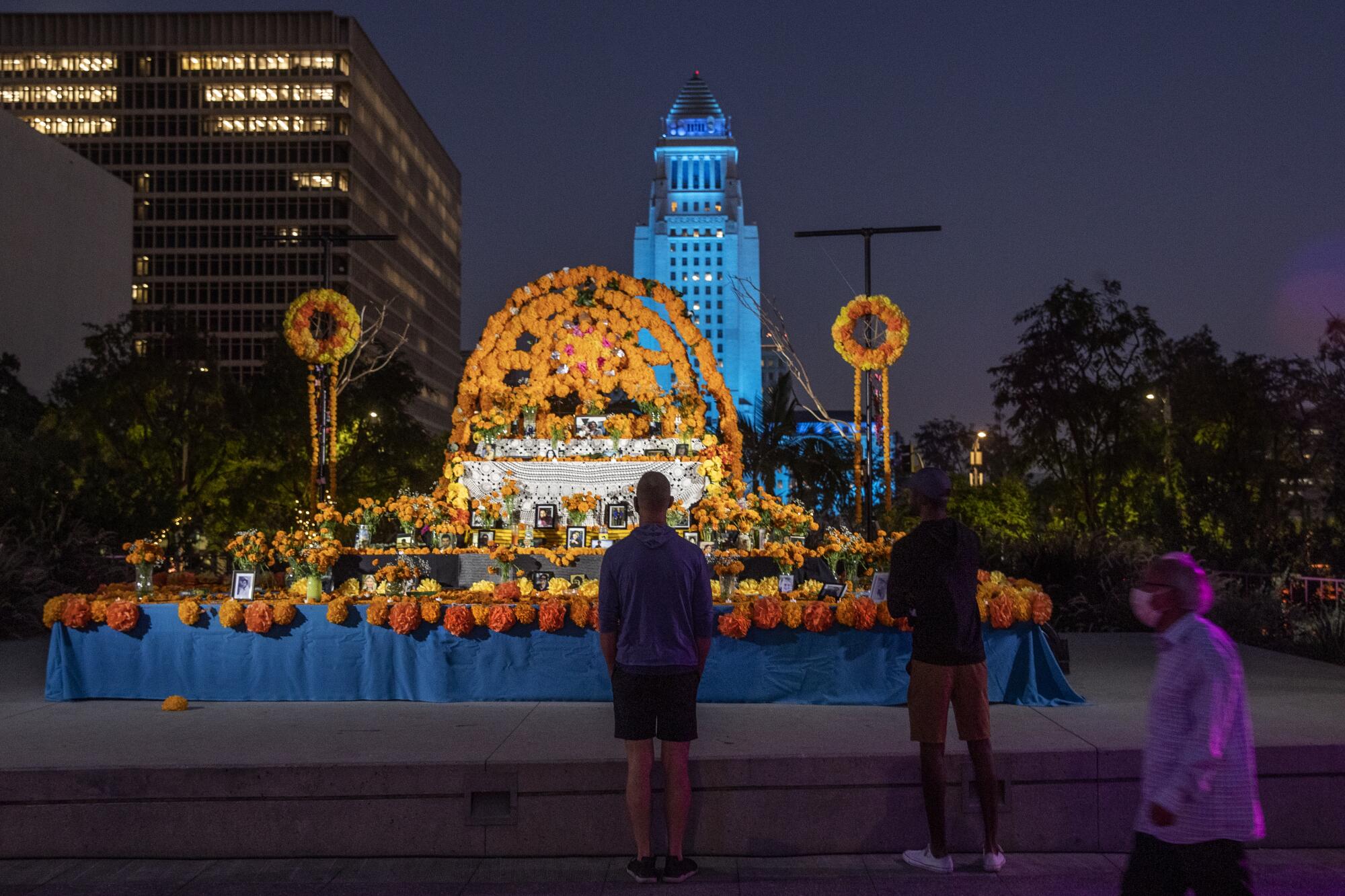 People stop before a community altar at downtown L.A.'s Grand Park. 