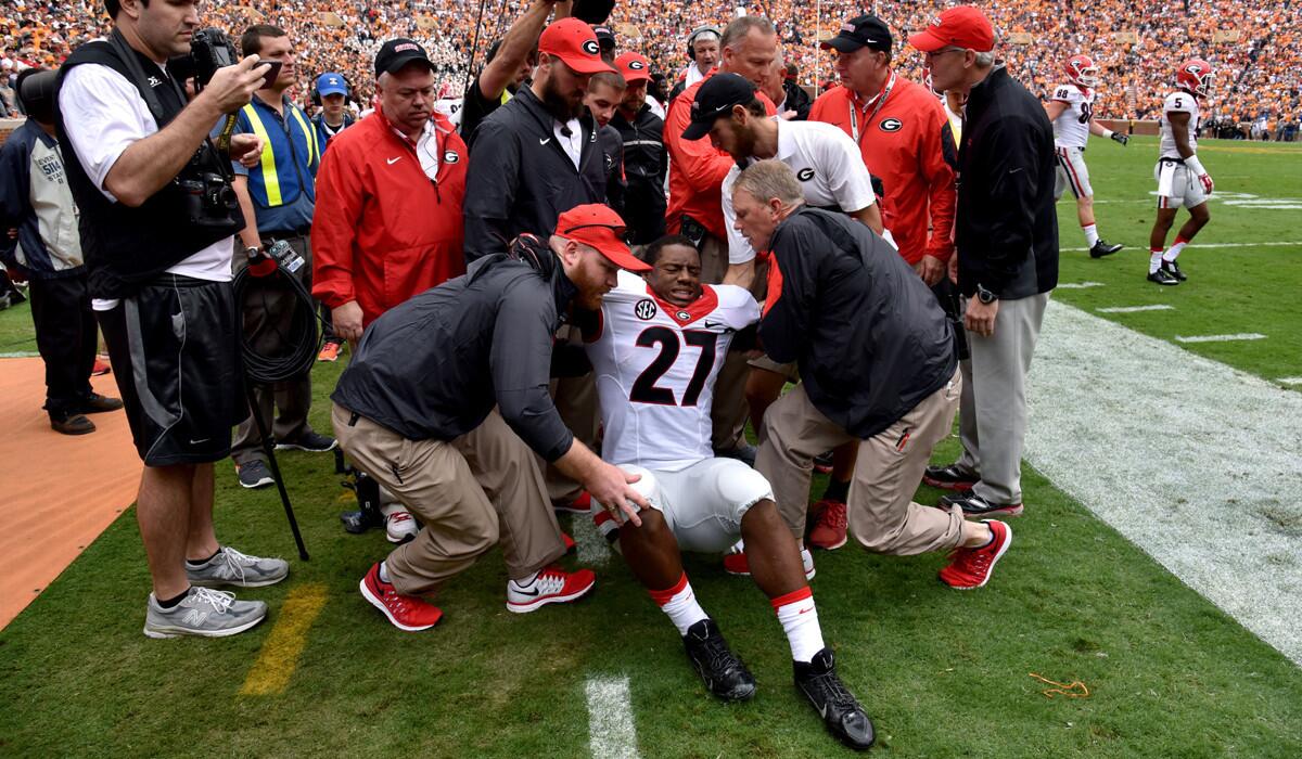 Georgia running back Nick Chubb is helped off the field after injuring his left knee on the first play from scrimmage during a game against Tennessee on Saturday.