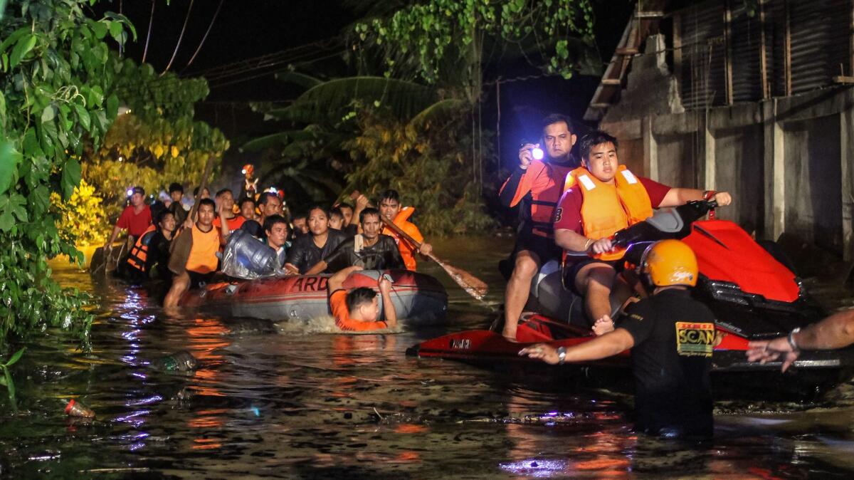 Rescue workers evacuate flood-affected residents in Davao on the southern Philippine island of Mindanao early Saturday.