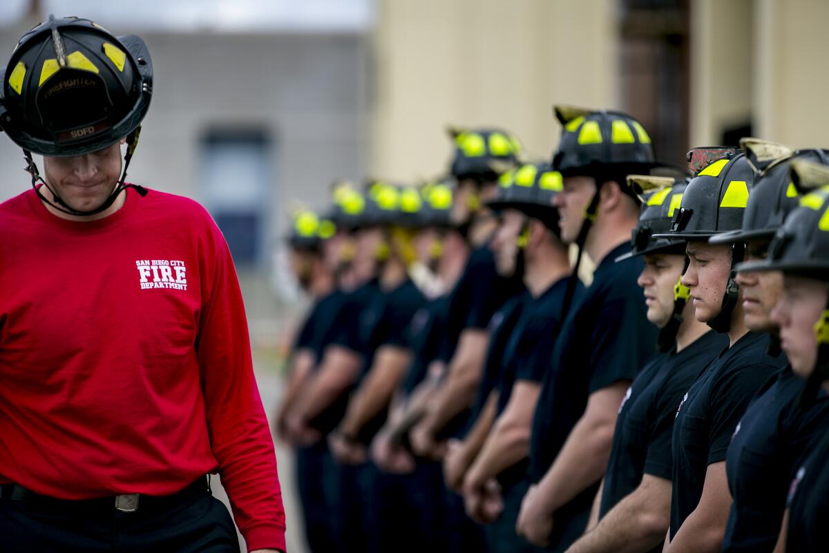 Instructor Charles Brookes lowers his head in front of recruits lined up during a fire academy in 2019.