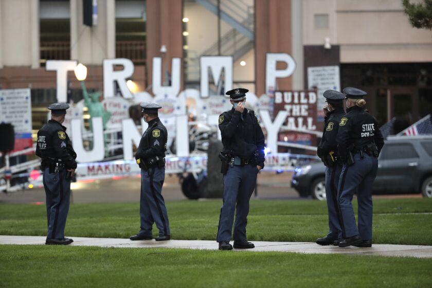 State Police troopers patrol during a rally at the State Capitol in Lansing, Mich., Thursday, May 14, 2020. (AP Photo/Paul Sancya)