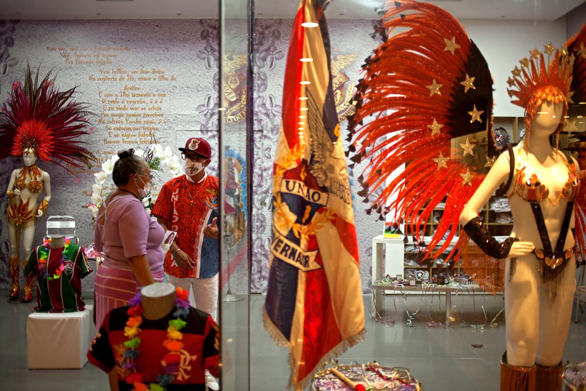 Eduardo Cerqueira das Chagas speaks with a customer in a store recently opened by the Uniao da Ilha samba school.