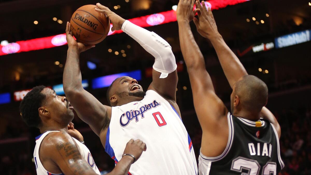Clippers power forward Glen Davis, center, puts up a shot over San Antonio's Boris Diaw, right, as DeAndre Jordan looks on during a Clippers' loss on Nov. 10.