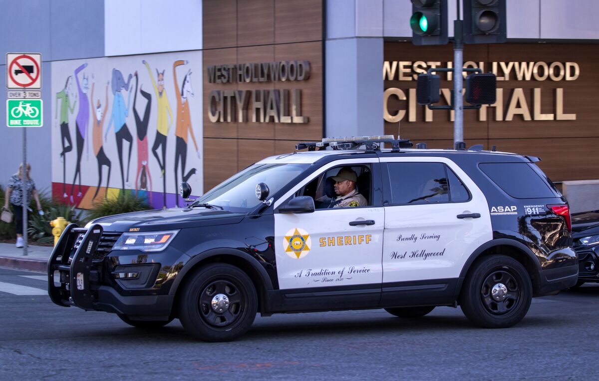 A sheriff's deputy drives past West Hollywood City Hall in a sheriff's SUV on October 28, 2021.