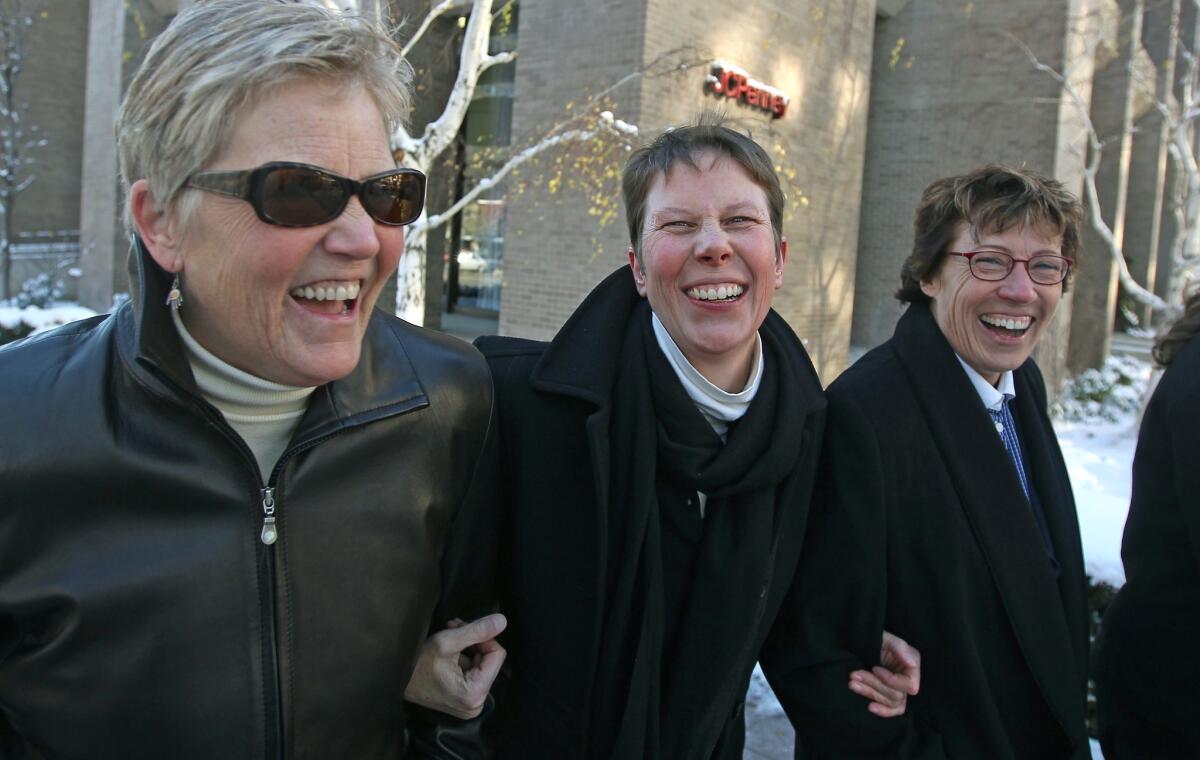 Plaintiff's Laurie Wood, left, and her partner, Kody Partridge, center, walk with their attorney Peggy Tomsic after leaving the Frank E. Moss U.S. Courthouse on Wednesday. A challenge to Utah's same-sex marriage ban by three gay couples was heard this week. A federal judge has struck down Utah's same-sex marriage ban Friday, saying it is unconstitutional.
