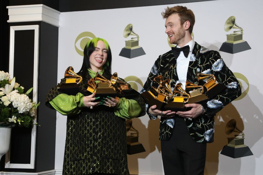 LOS ANGELES, CA - January 26, 2020: Billie Eilish in the press room with the awards for Record Of The Year “Bad Guy”, Album Of The Year “When We Fall Asleep, Where Do We Go?”, Song Of The Year “Bad Guy”, Best New Artist and Best Pop Vocal Album “When We Fall Asleep, Where Do We Go?” and Finneas O'Connell with the awards for Record Of The Year “Bad Guy”, Album Of The Year “When We Fall Asleep, Where Do We Go?”, Song Of The Year “Bad Guy”, Best Engineered Album, Non-Classical for “When We Fall Asleep, Where Do We Go?” and Producer Of The Year, Non-Classical backstage at the 62nd GRAMMY Awards at STAPLES Center in Los Angeles, CA. (Myung J. Chun / Los Angeles Times)