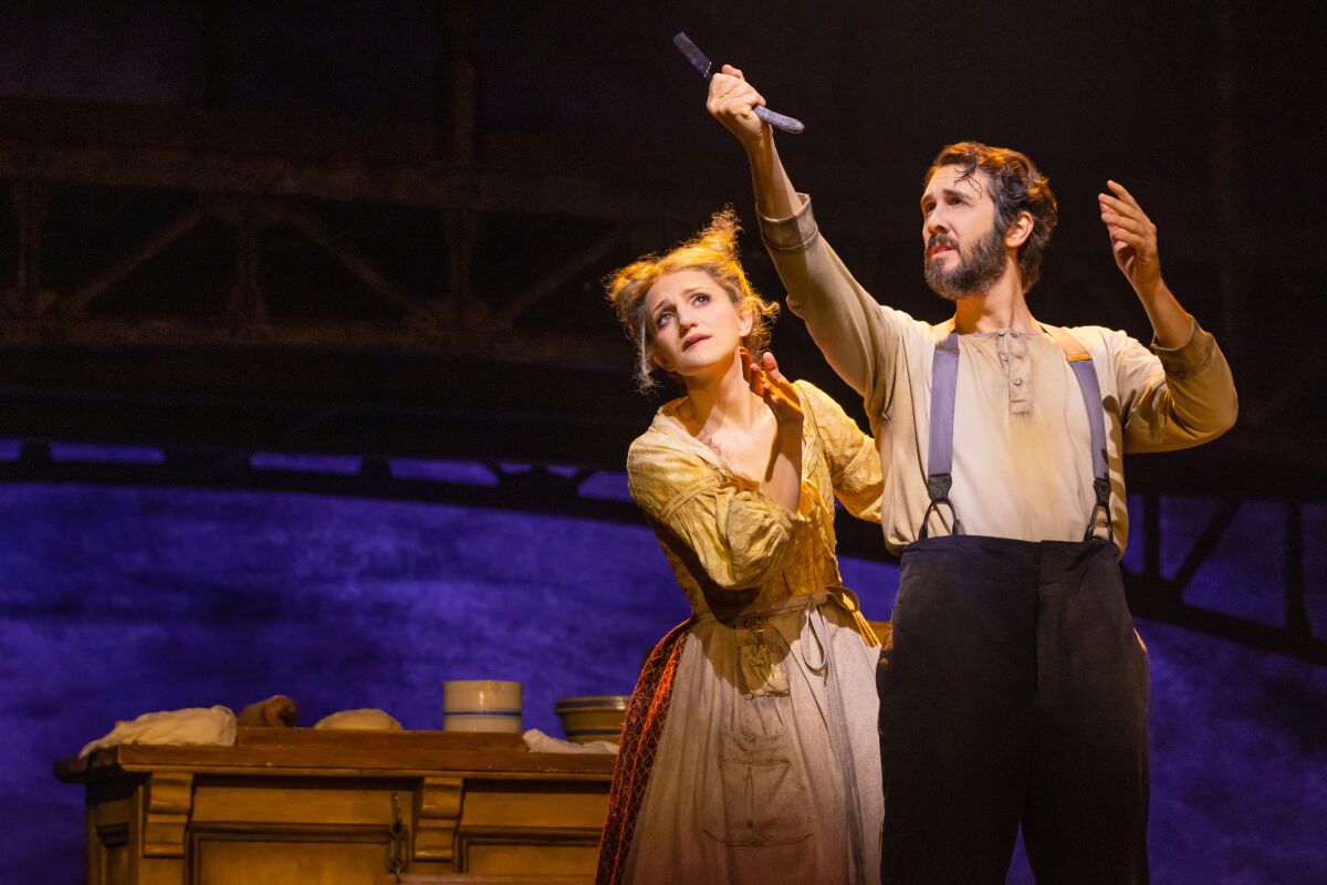 Josh Groban as Sweeney Todd raises a knife with Annaleigh Ashford at his side.