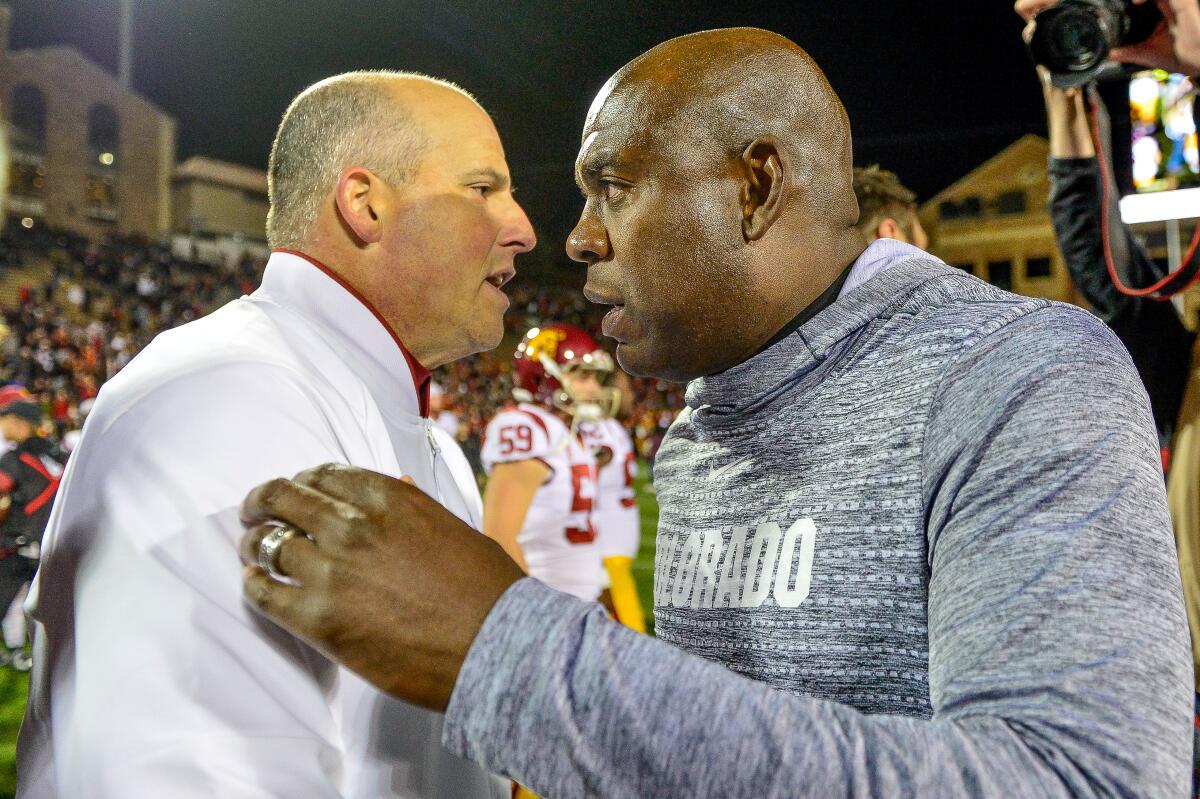 USC coach Clay Helton, left, and Colorado coach Mel Tucker meet on the field after the Trojans' 35-31 win Friday.