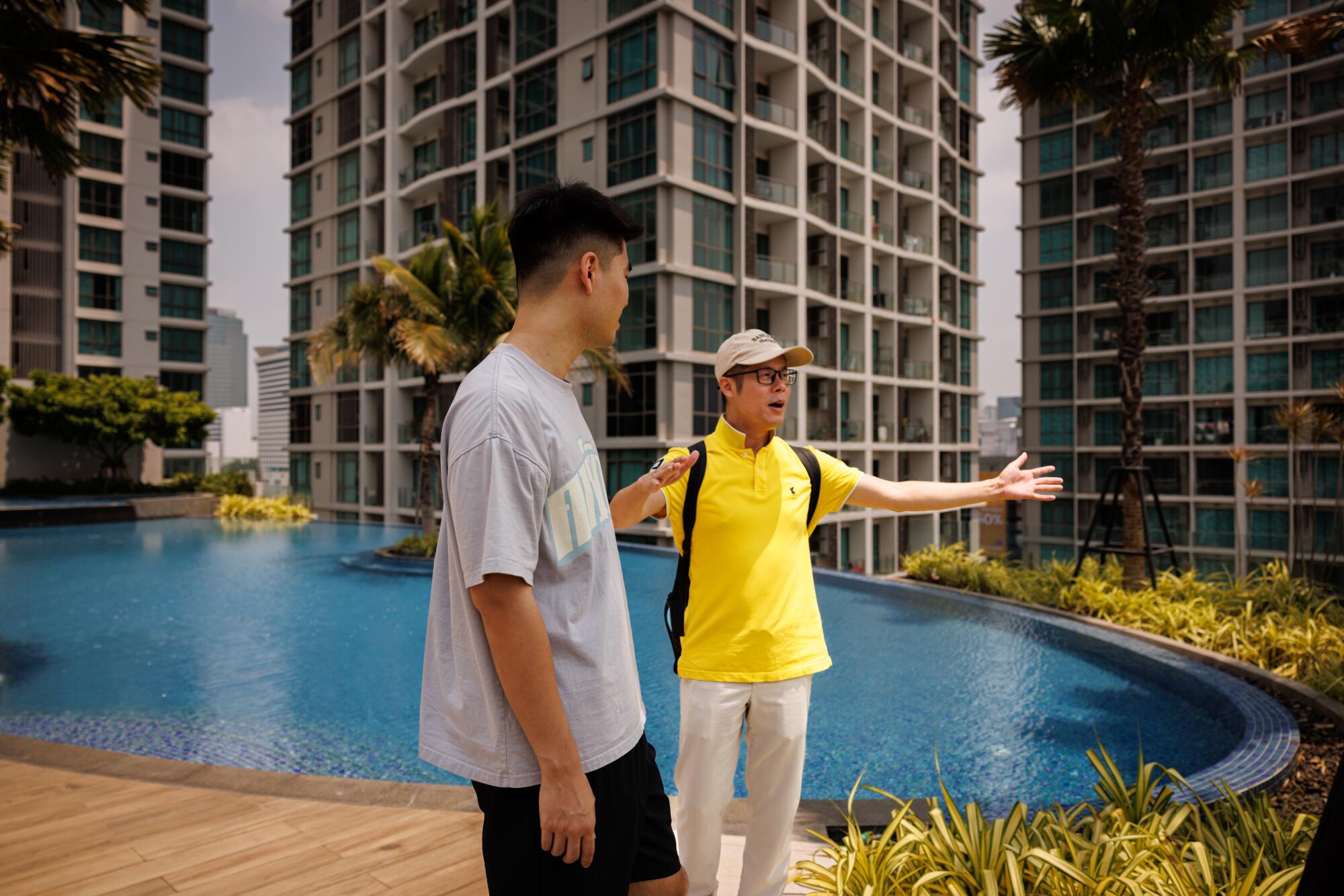 Prospective buyer, Danny Dong, 29, speaks with real estate agent, Owen Zhu, on the rooftop 