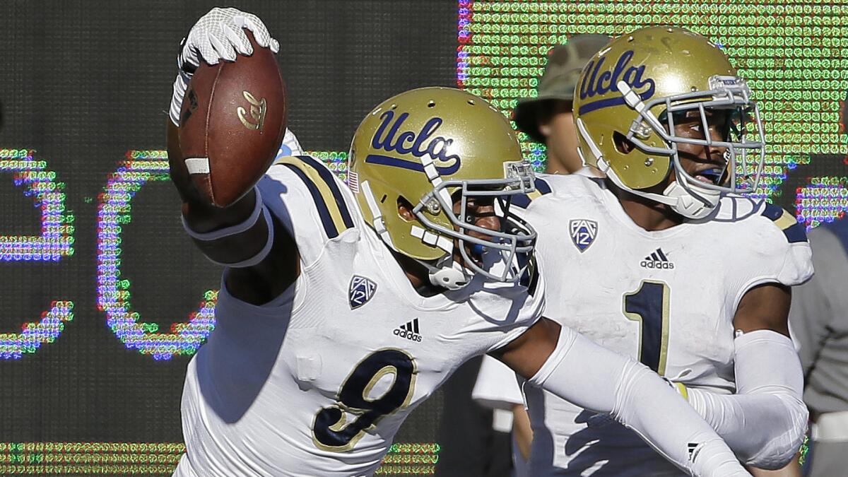 UCLA defensive back Marcus Rios, left, celebrates with teammate Ishmael Adams after intercepting a pass during the fourth quarter of the Bruins' 36-34 win over California on Saturday.