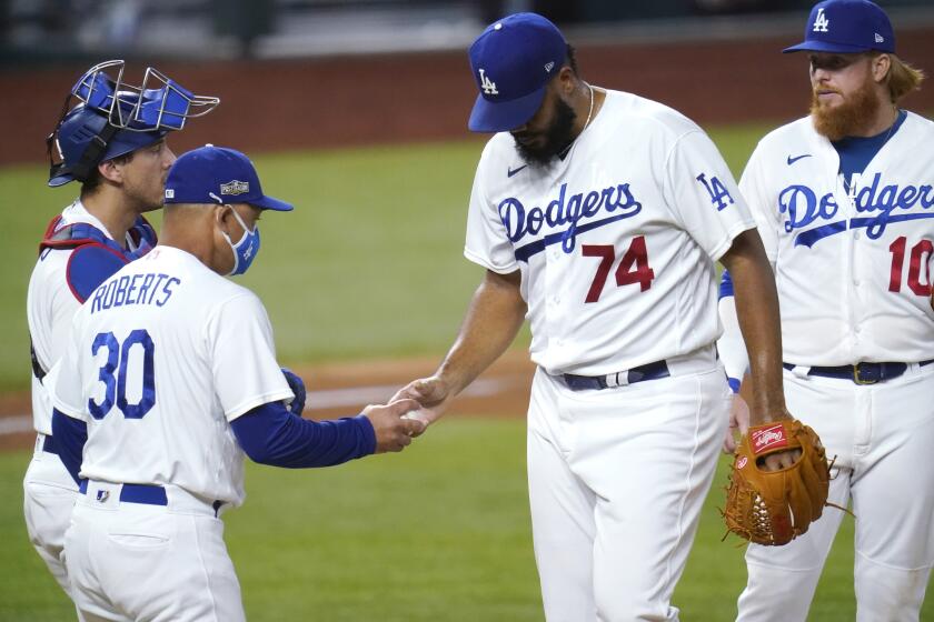Los Angeles Dodgers manager Dave Roberts, left, takes Los Angeles Dodgers' Kenley Jansen.