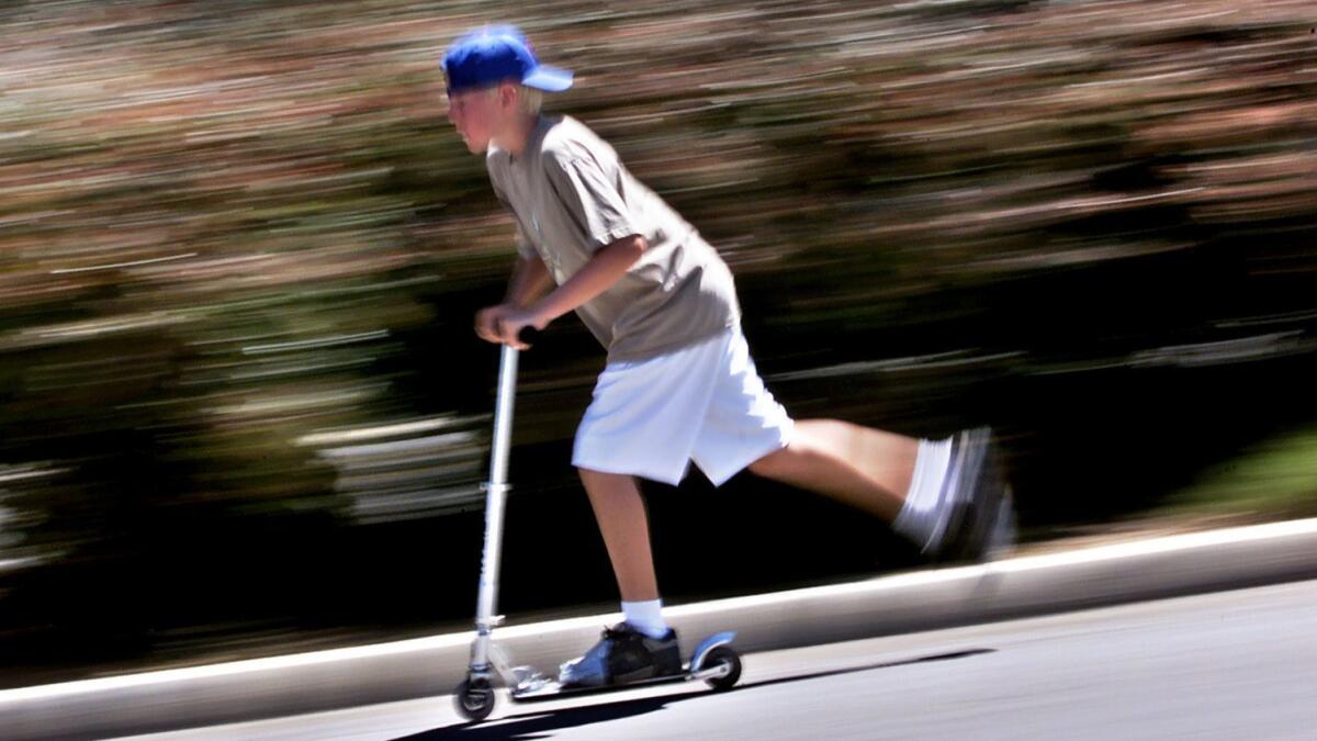 Shown in July 2000, Kyle Johnson of Thousand Oaks rides his Razor scooter in a parking lot.