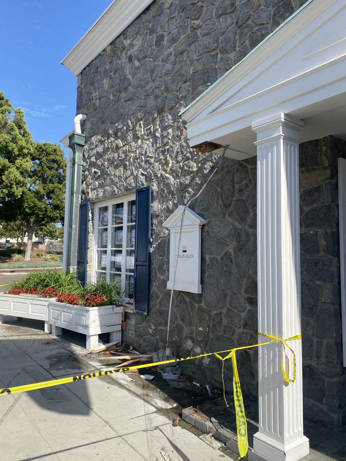The car caused damage to the building's exterior, including knocking down one of the columns and a small electrical box.