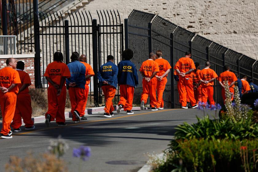 Inmates walk in file at San Quentin State Prison. A former inmate there was convicted this week of stealing the identities of his fellow prisoners to file fraudulent tax returns.