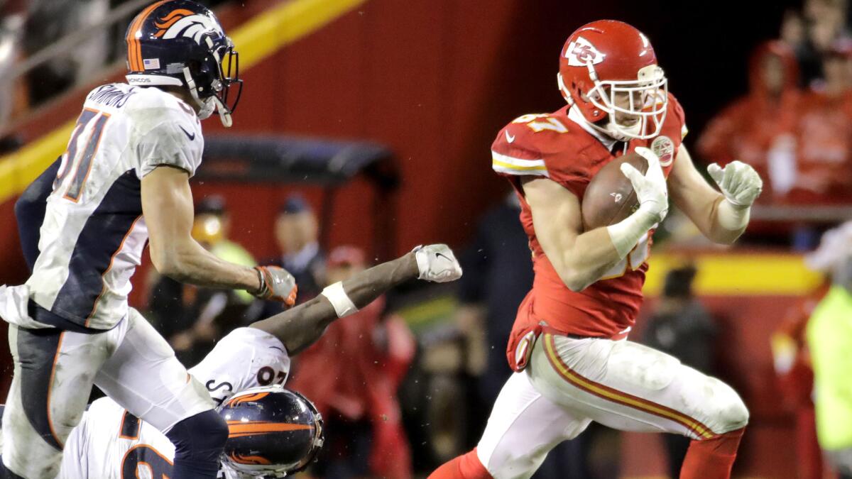 Chiefs tight end Travis Kelce picks up big yards as he evades Broncos defenders Darian Stewart (diving) and Justin Simmons during the second half Sunday.