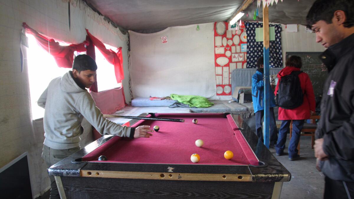 Boys play pool in the Jungle Books Kids Cafe. The cafe has provided a place where young people in the Calais refugee camp can listen to music, play games, eat warm food and charge their cellphones.
