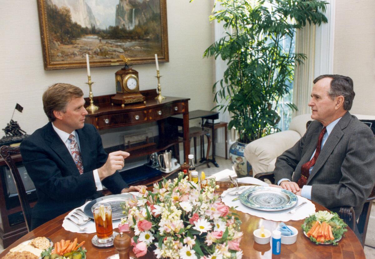  Vice President Dan Quayle, left, briefs President George Bush during lunch at the White House.