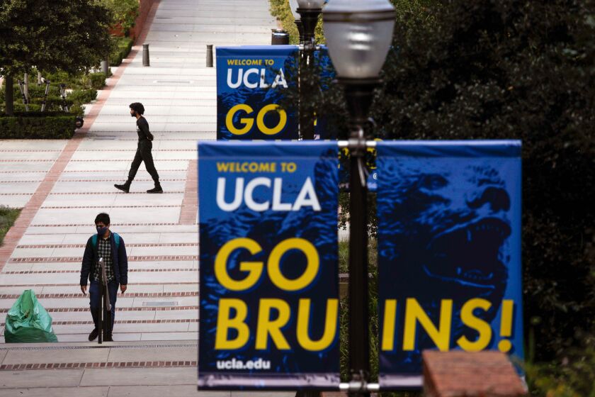 Students walk through a near empty campus at UCLA 