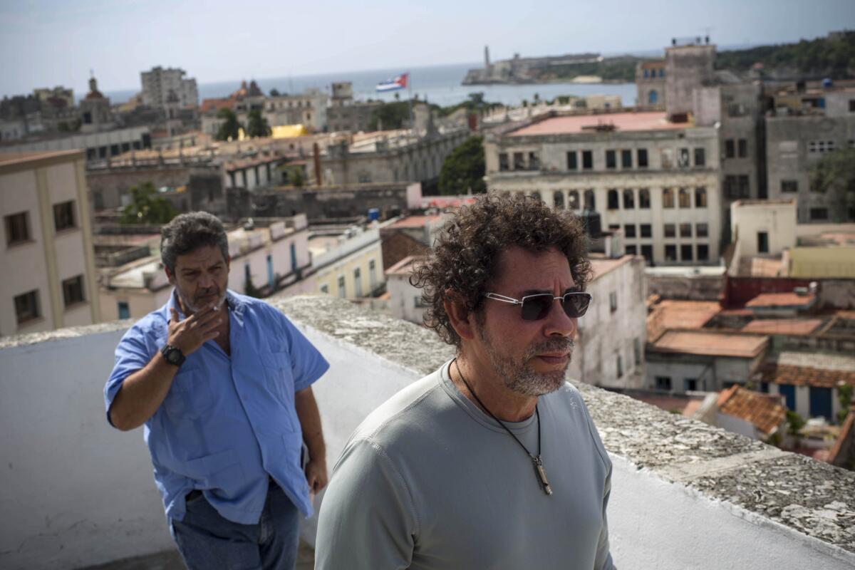 El comandante de las FARC Pastor Alape, a la derecha, camina en la terraza de un edificio en el centro histórico de la capital cubana acompañado por el rebelde Marco León Calarca después de una entrevista.