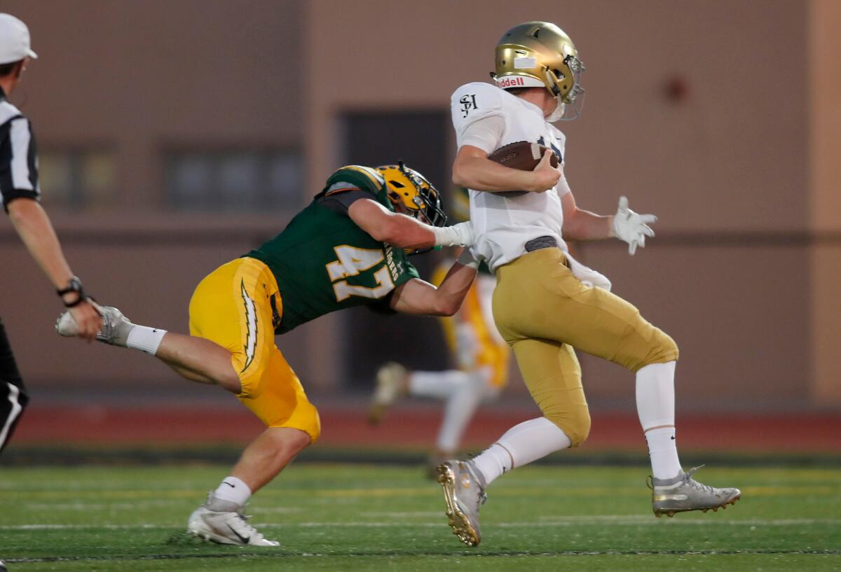 Edison's Bryce Gilbert, left, tackles San Juan Hills quarterback Hudson Jones during the first half of a nonleague game at Huntington Beach High on Friday.