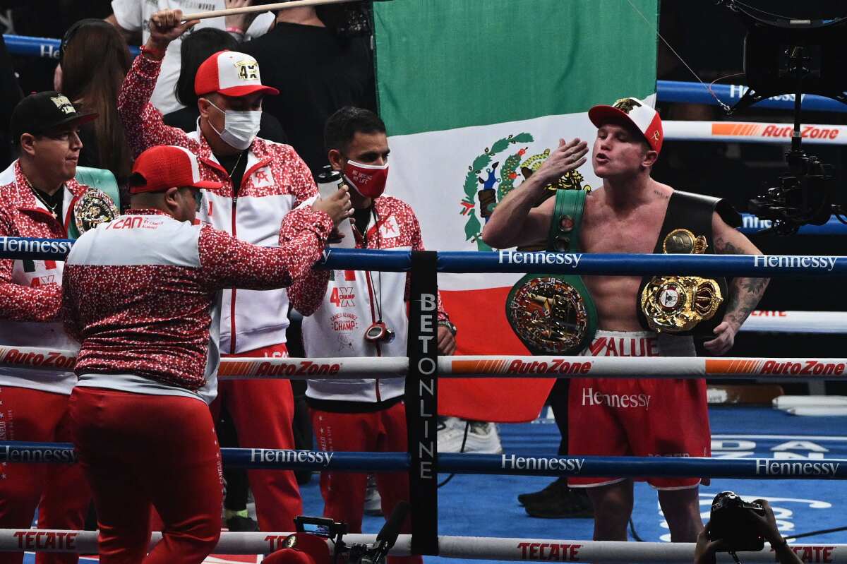 Canelo Alvarez celebrates in the ring with his coaches and trainers after defeating Callum Smith.