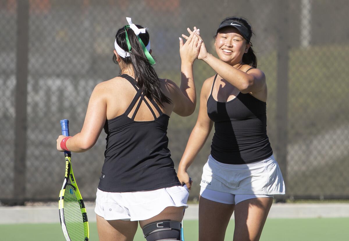 Sage Hill's Madison Dao, left, gets a high-five from her partner Julia Yuen during a San Joaquin League match against St. Margaret's on Tuesday.