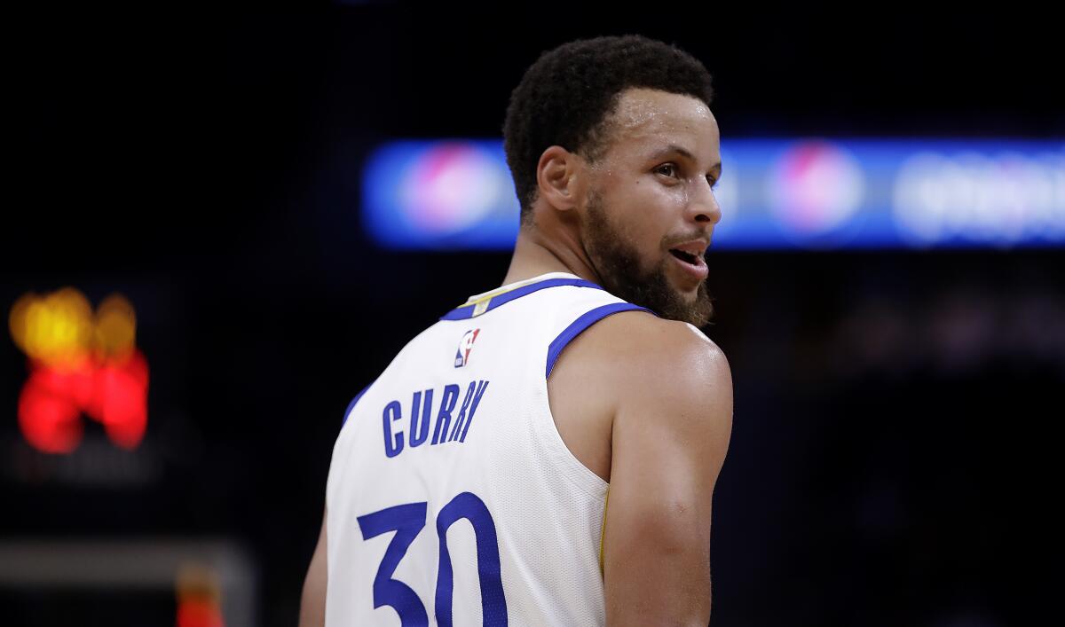 Warriors guard Stephen Curry glances at the Lakers bench during a preseason game in San Francisco on Oct, 18, 2019.