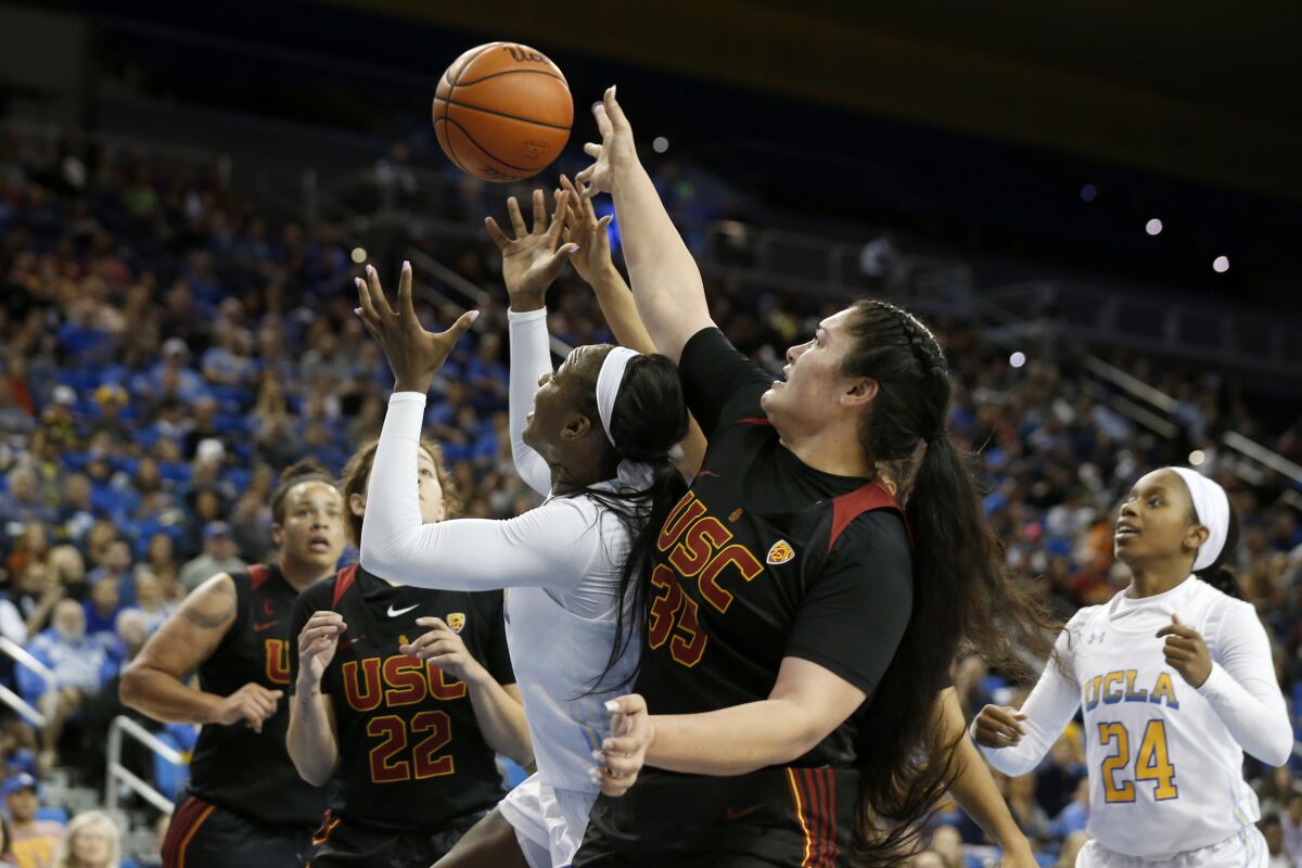 UCLA forward Michaela Onyenwere (21) and USC forward Alissa Pili (35) fight for a lose ball during a game at Pauley Pavilion on Dec. 29.