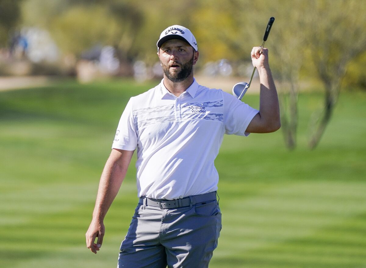 Jon Rahm gestures after putting on the eighth green during the Phoenix Open golf tournament Thursday, Feb. 10, 2022, in Scottsdale, Ariz. (AP Photo/Darryl Webb)