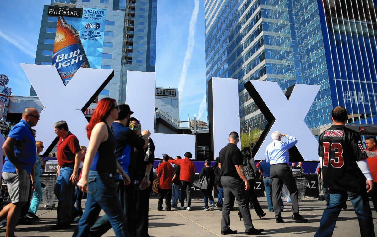 NBC has sold each 30-second Super Bowl commercial spot for an average of $4.5 million. Above, people walk past a Super Bowl logo in Phoenix.