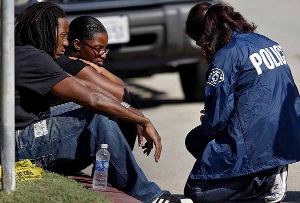 Ben Dixon, brother of the mother who allegedly shot her two children, speaks with police near the apartment where the shooting took place.