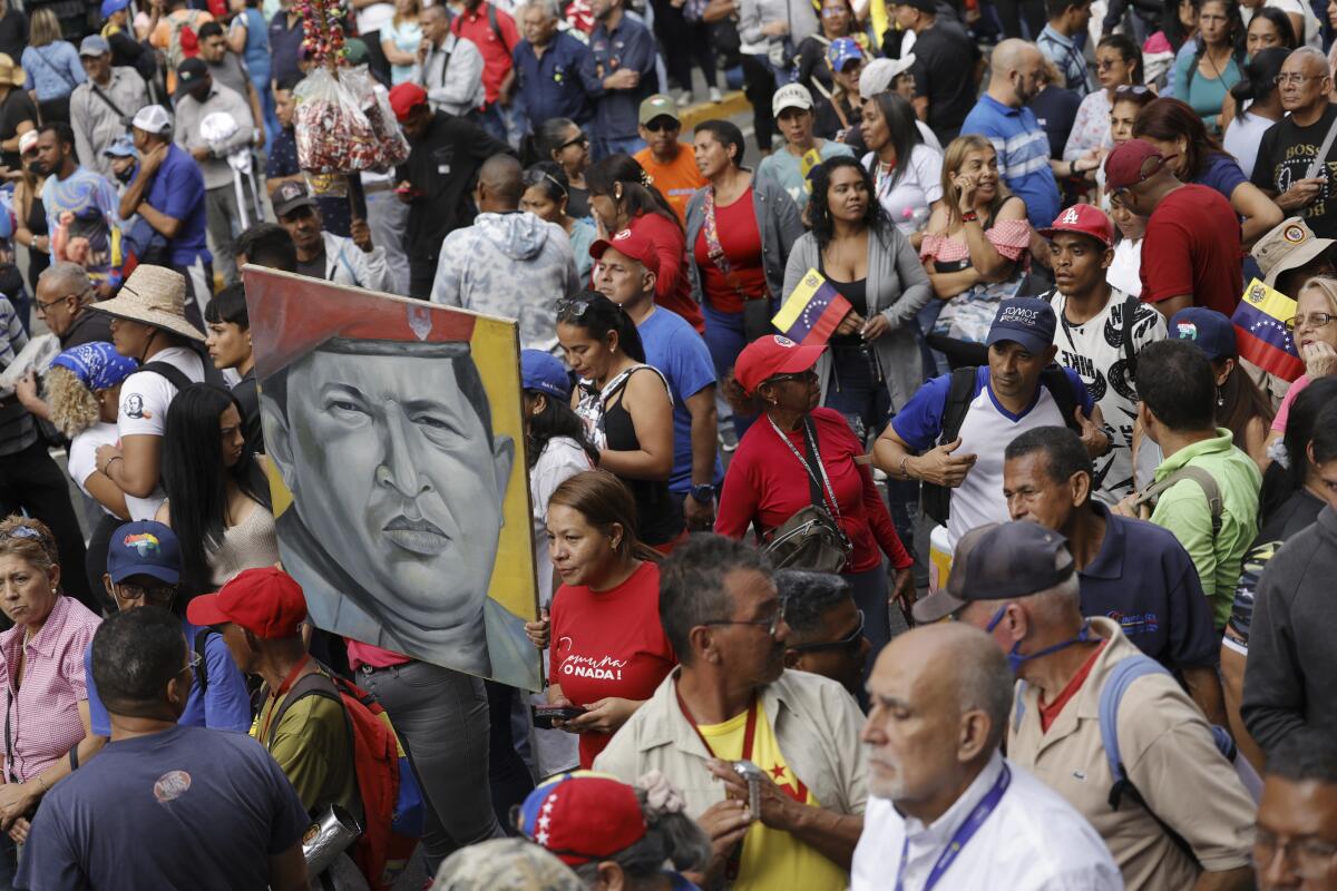 Demonstrators holding up an image of late Venezuelan President Hugo Chávez