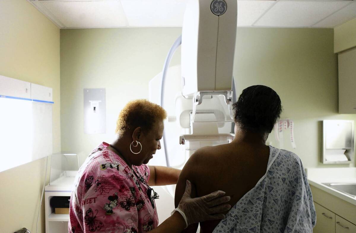 A woman has a routine mammogram in Chicago. Results of a Danish study about the long-term psychological effects of false-positive scares raise new questions about how often women need to have such cancer screenings.