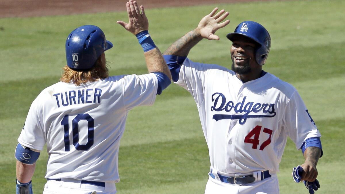 Dodgers second baseman Howie Kendrick (47) celebrates with third baseman Justin Turner after the two scored on a grand slam by teammate Chris Heisey in the fifth inning Thursday afternoon.
