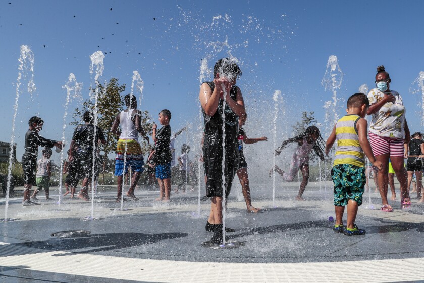 Children frolic in a playground water fountain on Labor Day.