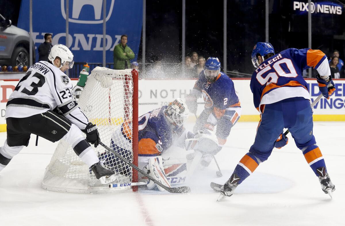 Islanders goalie Jean-Francois Berube (30) looks for the rebound as defenseman Adam Pelech (50) clears the puck away from Kings right wing Dustin Brown (23) during the first period on Jan. 21.
