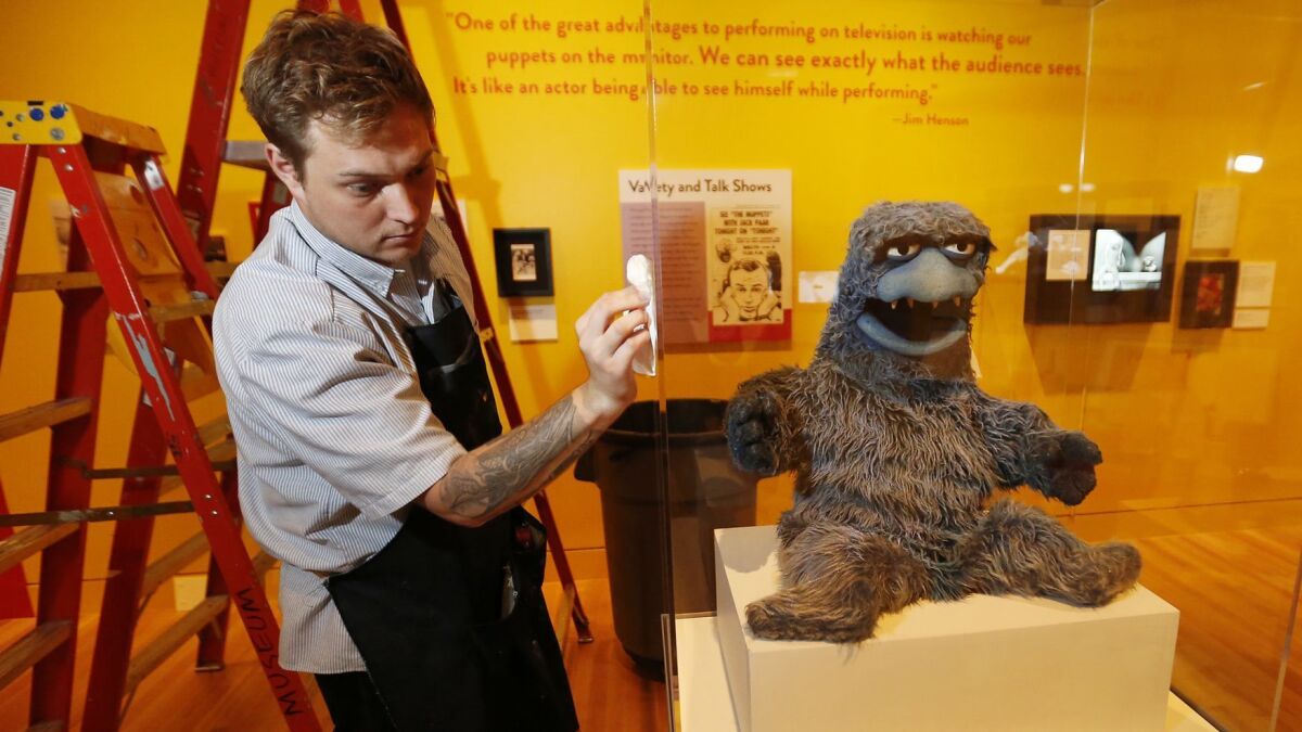 Technician Cole Carter prepares the Beautiful Day puppet, 1966, for display in "The Jim Henson Exhibition: Imagination Unlimited” at the Skirball Cultural Center.