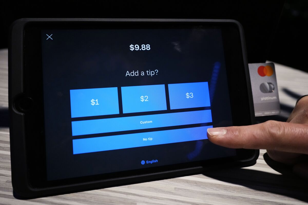 A tipping option is displayed on a card reader tablet.